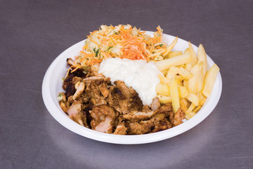 Potato slices, fried meat and salad on a dish