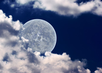 The moon in clouds on a background of the night sky.