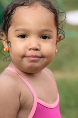 A close-up of a wet playful toddler girl