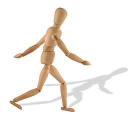 close-up of a running wooden figure with its shadow