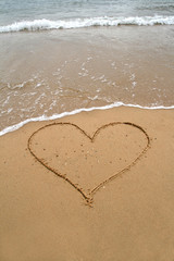 Fototapeta na wymiar heart in the sand of the beach