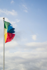 Flag with colors of the peace in the blue sky