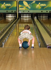a little girl playing a game of bumper bowling