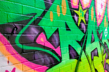 Graffiti with neon colors sprayed on a brick wall 