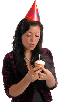 A Pretty Young Woman Blowing Out A Candle