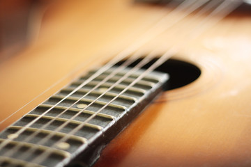 Fototapeta premium Close-up of wooden acoustic guitar, focus on strings