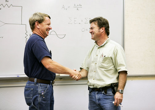 An adult student shaking hands with his teacher