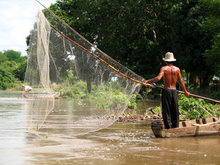 fisherman with large net in river