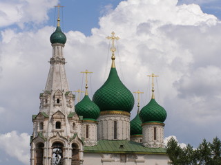 Fototapeta na wymiar Age-old khrestian church with green domes and gold crosses