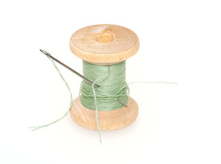 old wooden spool of thread  with  needle  