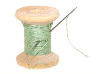 old wooden spool of thread  with  needle  