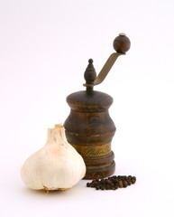 Old-fashioned pepper mill with garlic and black pepper