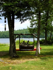 Fototapeta na wymiar Wooden swing overlooking rural lake and mountains
