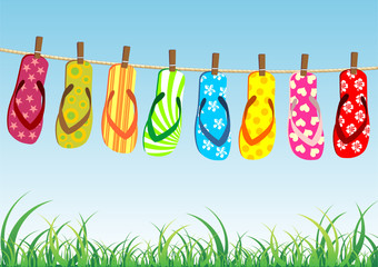 Beach sandals. Different colorful flip-flops hanged on a rope.