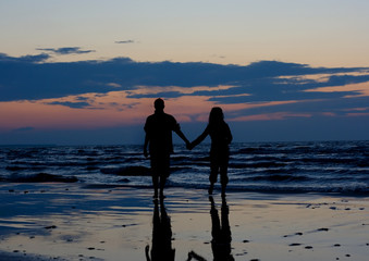 Couple near sea at sunset.