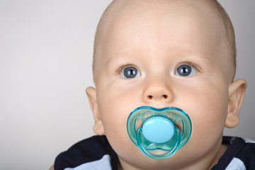 A portrait of a baby with a dummy