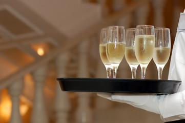 waiter with dish of vine glasses