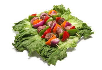 Three colorful kabobs over a bed of lettuce
