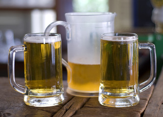two mugs of beer and a jug
