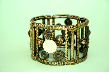 Metallic ancient style bracelet with ornaments and stones.