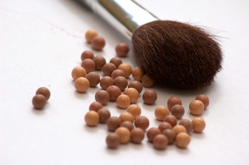 Brush and balls of powder for make-up 