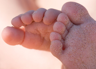 feet of a little girl in the sand