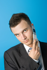 Attractive young businessman in black suit with mobile phone. 