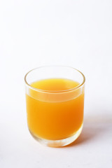 A glass of orange juice on a white background