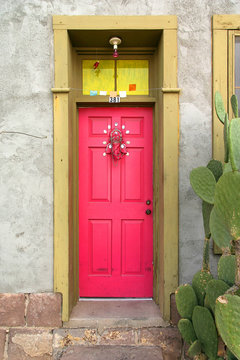 Adobe house doorway with pink colorful door