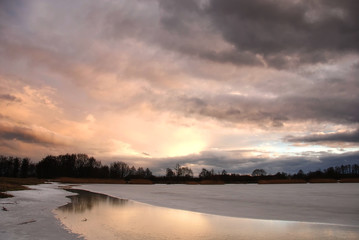 Sunset by the frozen lake
