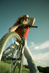 The charming girl smiles on a bicycle
