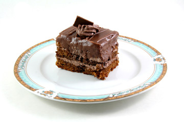 slice of chocolate cake on a lukury plate isolated on white
