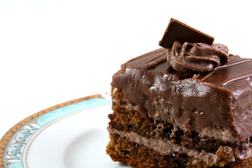 slice of chocolate cake on a lukury plate isolated on white
