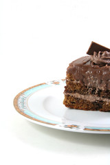 slice of chocolate cake on a lukury plate isolated on white