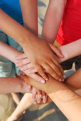 Hands of diverse group of teenagers joined in union