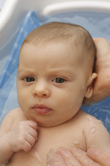 A month old infant girl in a bath. 