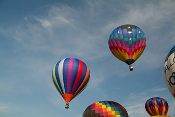 Ascending colorful hot air balloons into a blue sky