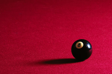 An 8 ball on pool table, dramatic side lighting