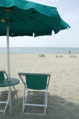 Green empty chairs with parasol on the beach