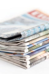 Stack of newspapers on white background