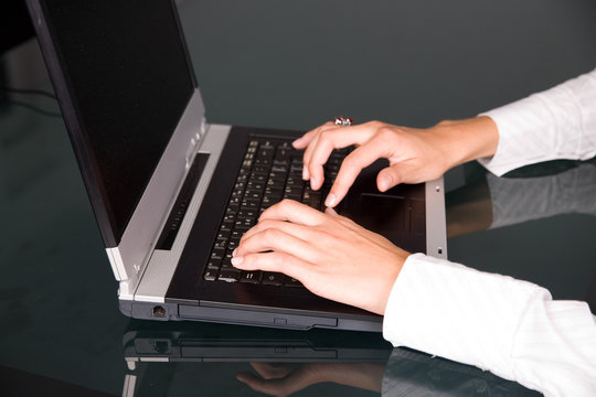 hands of handsome woman on notebook's keyboard
