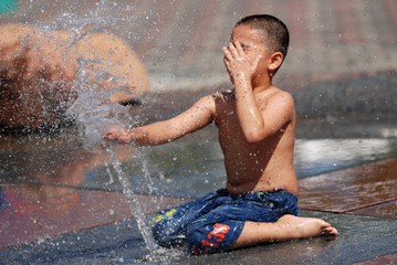 children playing water at the water fountain