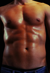 Fototapeta premium Handsome shiny naked muscular male body isolated on black