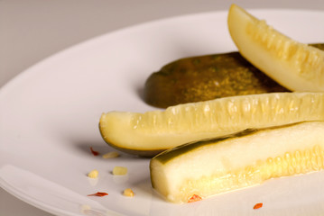 Kosher dill pickle spears on a white plate 