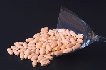 Pills in a martini glass - Drug abuse concept.