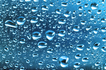 Water droplets on a blue toned brushed steel surface.