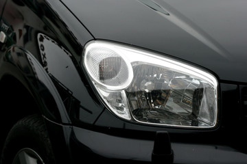 Obraz na płótnie Canvas Reflektor z czarnym luksusowy samochód