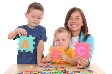 Fototapeta premium children and mother playing with letters isolated on white