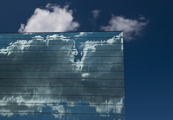 Reflected clouds in glass building