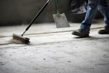 Construction worker sweeping up - obrazy, fototapety, plakaty